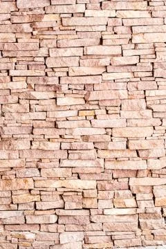 Textured background made of light red stones wall Stock Photos