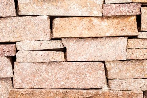 Textured background made of light red stones wall Stock Photos
