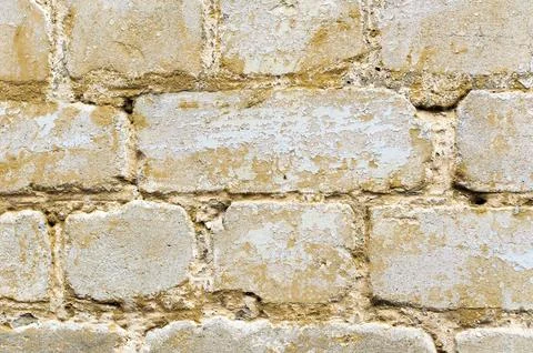 Textured background of a multi-colored brick painted in yellow. A sizzling 스톡 사진