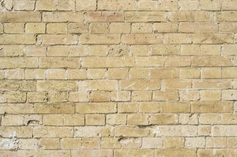 Textured background of a stone brick of yellow antediluvian masonry. Partially Stock Photos