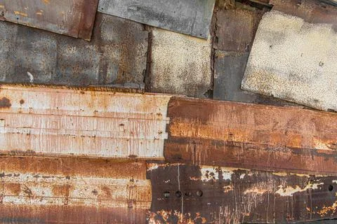 The textured barrack wall is made of rusty metal sheets and scrap metal. Stock-Fotos