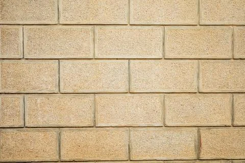 Textured beige brick wall pattern with horizontal staggered layout Stock Photos