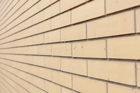 Textured beige brick wall surface in shallow depth of field Stock Photos