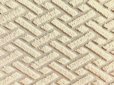 Textured beige fabric background featuring raised geometric patterns of paral Stock-Fotos
