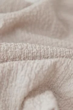 Textured beige fabric background with selective focus Stock Photos