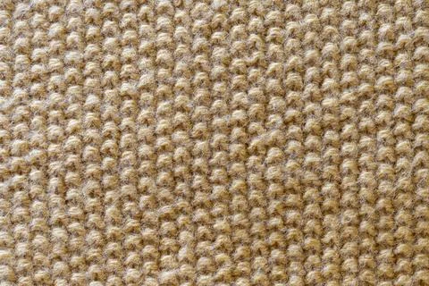 A textured, beige fabric with a woven pattern. Stock Photos