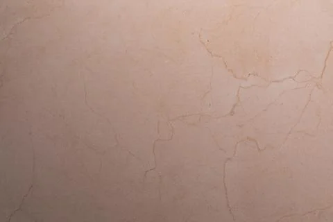 Textured beige stone surface with subtle cracks and patterns in natural light Foto stock