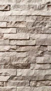 Textured beige stone wall background with rustic stacked bricks Stock Photos