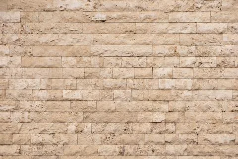 Textured beige stone wall with rectangular blocks in a modern architectural 스톡 사진