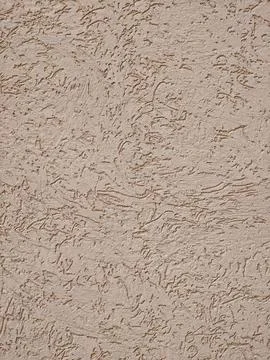 Textured beige stucco wall surface with organic brush strokes and subtle sh.. Stock Photos
