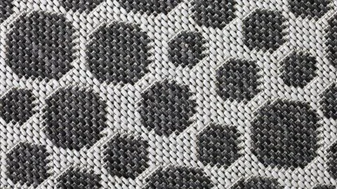 Textured black and white pattern featuring circles on a woven fabric surface Stock Photos