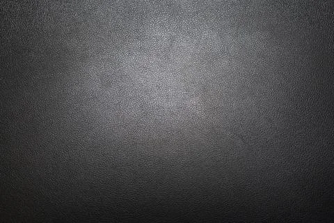 Textured black leather surface with a soft sheen, ideal for backgrounds and Stock-Fotos