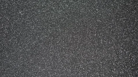 Textured black surface with fine glitter particles creating a shimmering effe 스톡 사진