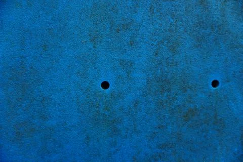 A textured blue background with two small dark circular holes visible Stock Photos