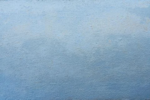 Textured blue painted wall surface showing subtle color gradient and rough Stock Photos