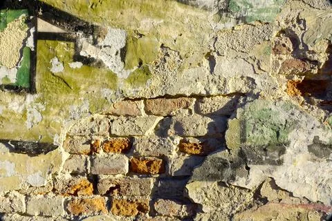 Textured Brick Wall Background With Peeling Paint and Colorful Patches in N.. Stock Photos