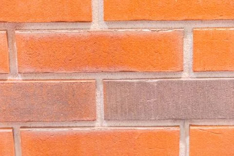Textured brick wall featuring a mix of orange and brown bricks with a rusti.. Stock Photos