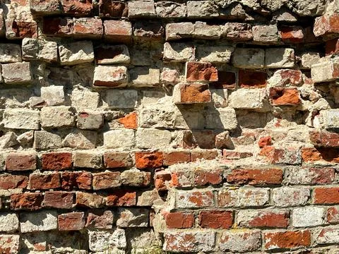 Textured brick wall featuring a mix of red and beige bricks Stock Photos
