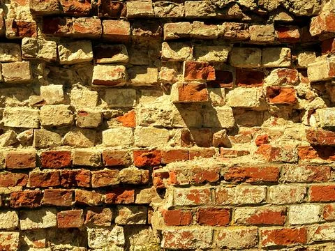 Textured brick wall featuring a mix of red and beige bricks Stock Photos
