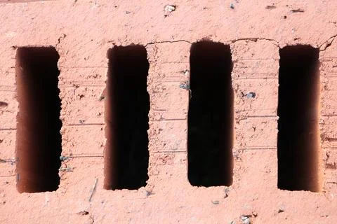 A Textured Brick Wall featuring Vertical Openings which creates an interesting Stock Photos