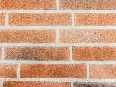 Textured brick wall featuring a warm color palette with varying shades of orange Stock Photos