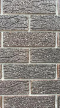 Textured brown brick wall with unique patterns enhancing architectural appe.. Stock Photos