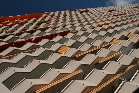 Textured building facade with rows of angular balconies in Barcelona, Spain Stock Photos