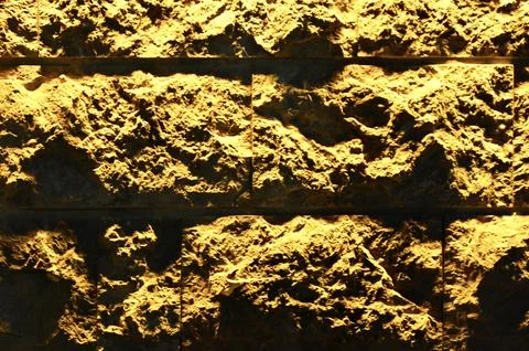 Textured Ceramic Wall Lit with Warm Light Stock Photos