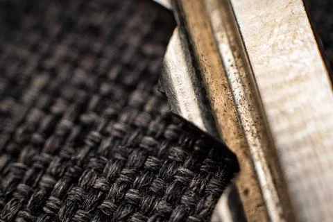 Textured closeup of dark fabric and metallic scissors showcasing intricate Stock Photos