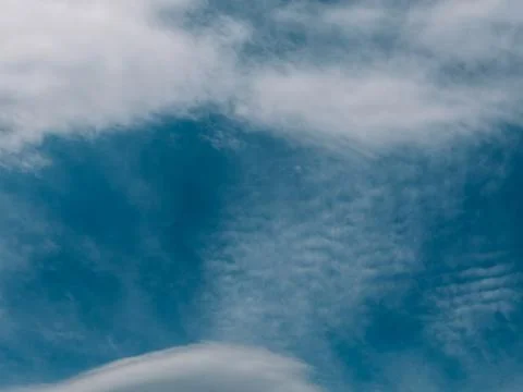 Textured cloud layers over deep blue sky, atmospheric nature background Stock Photos