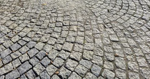 Textured cobblestone pavement in a circular pattern. Ideal for backgrounds in Stock Photos