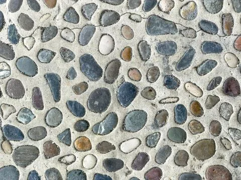 Textured cobblestone wall pattern with rounded stones in earthy hues Stock Photos