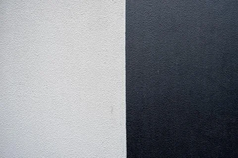 Textured concrete wall divided in two sections - black and white Stock-Fotos