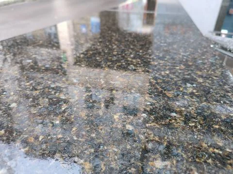 Textured dark granite tile surface with a smooth and polished finish. Stock Photos