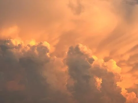 Textured dramatic cumulus orange heap of clouds on sky at sunset Stock Photos