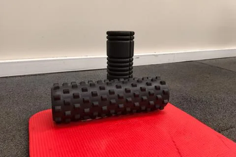 Textured foam roller on red mat enables deep tissue massage. effective foam.. Stock Photos