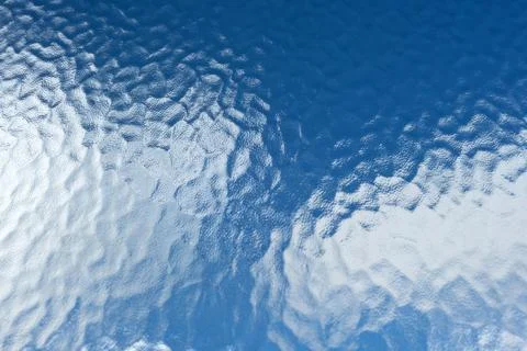 Textured Glass Window with Dimpled Pattern Overlooking Blue Sky and Clouds Stock Photos