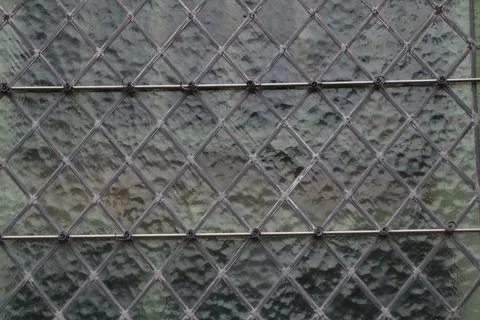 Textured glass with wire mesh pattern, perfect for vintage architectural design Stock Photos