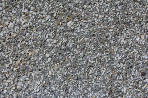 Textured gray aggregate surface displaying various stone sizes and colors Stock Photos