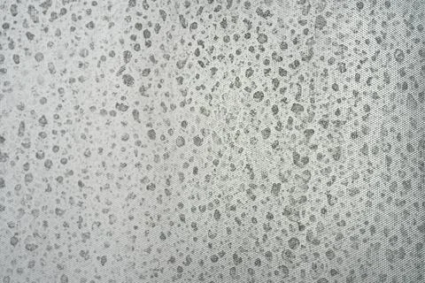 A textured gray background features an irregular pattern of darker spots Foto stock