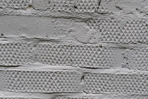 Textured gray brick wall with geometric patterns Stock Photos