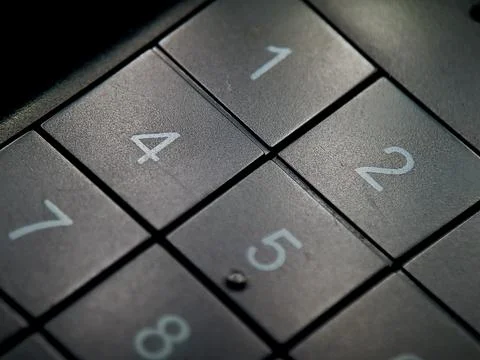 Textured gray keypad displaying numerical values with contrasting white fon.. Stock Photos