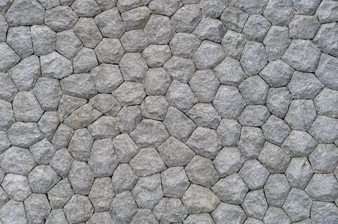Textured gray stone wall with interlocking hexagonal pattern Stock Photos