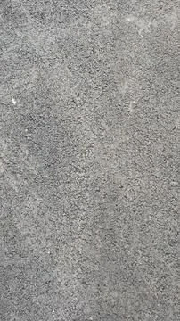Textured gray surface showing fine details of gravel and stone aggregate in.. Stock Photos