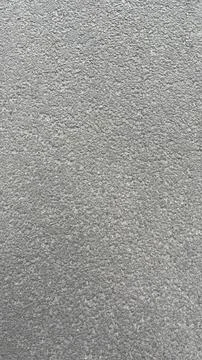 Textured gray surface showing subtle variations in tone and pattern under n.. 스톡 사진