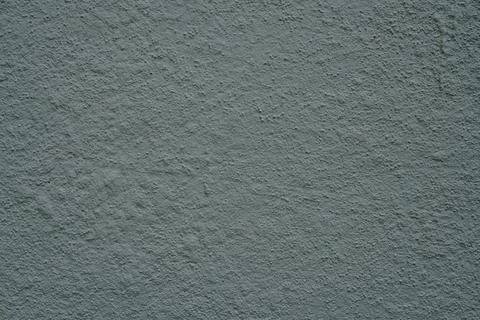 A textured gray wall surface with a rough stucco-like finish 스톡 사진