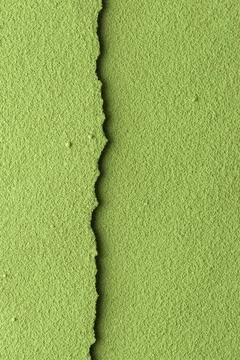 Textured green matcha powder split by narrow seam at center on vertical frame Stock Photos