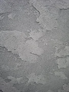 Textured grey plaster wall shows sturdy design with concrete look and rugge.. Photos