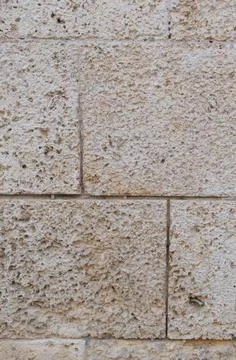 Textured limestone wall forming rough brick pattern Stock Photos