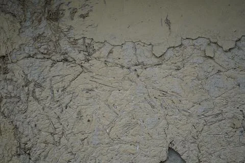 Textured mud wall surface with cracks and weathered plaster in a rural village s Stock Photos